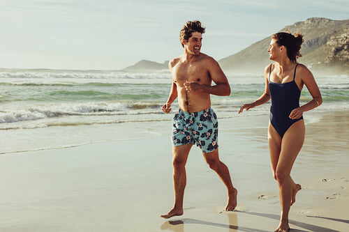 Beautiful couple running along the beach