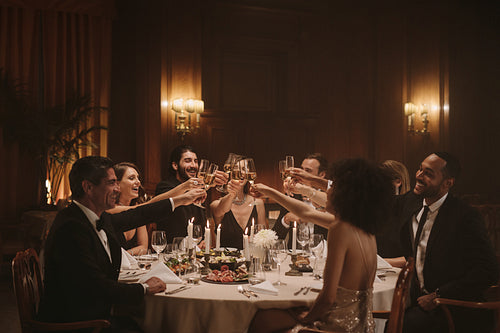 Socialites celebrating with wine at dinner party