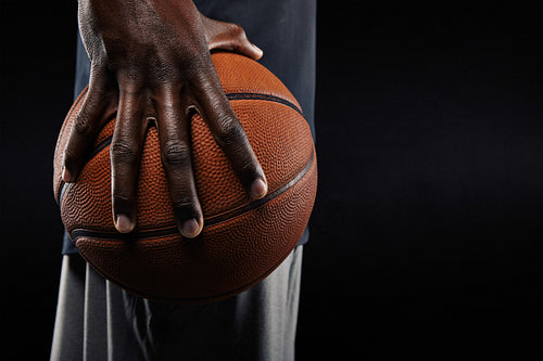 Hand of basketball player holding a ball