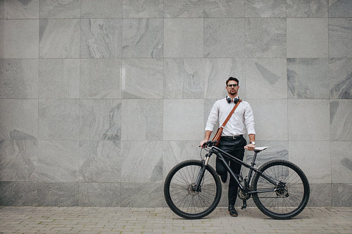 Man standing with a bicycle in street