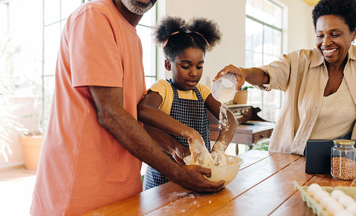 Baking in the kitchen: A family making a delicious cake