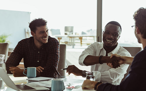 Three businessmen in a meeting shaking hands