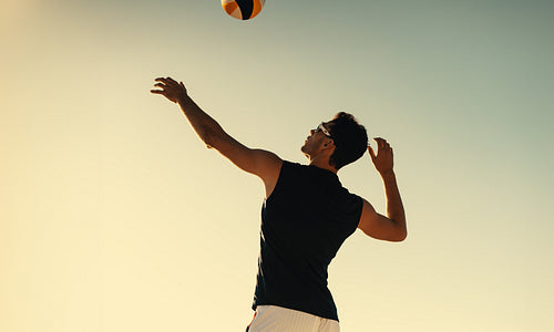 American athlete blocking ball in beach volleyball tournament