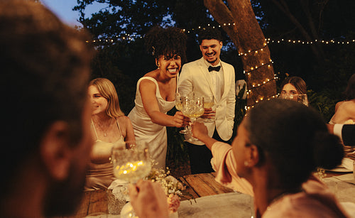 Bride and groom celebrating with friends at an intimate outdoor garden wedding