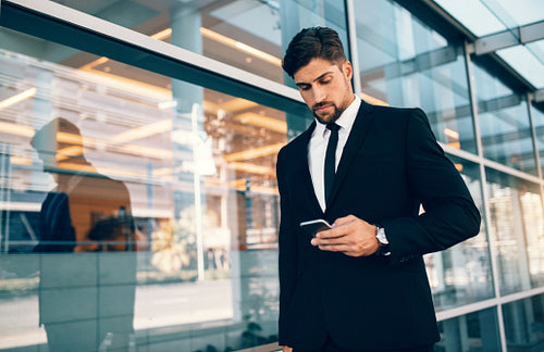 Businessman using mobile phone at airport