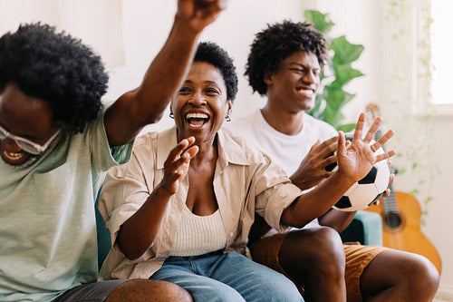 Family celebrates their team's victory in a televised football game