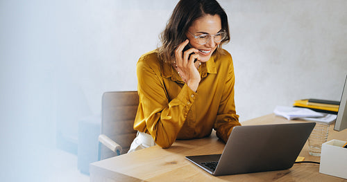 Successful businesswoman making a professional phone call in her office