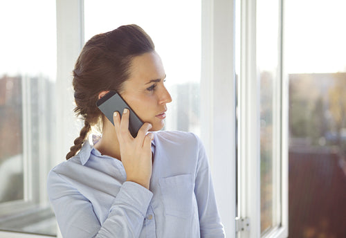 Young caucasian female in office using phone