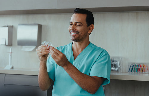 Orthodontist guides a dental professional examining a clear aligner in the clinic