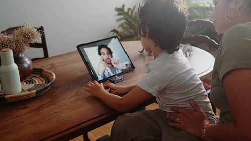 Virtual doctor visit: Mother and son consulting a doctor online using a tablet