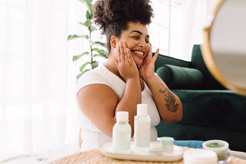 Smiling woman doing skin care at home
