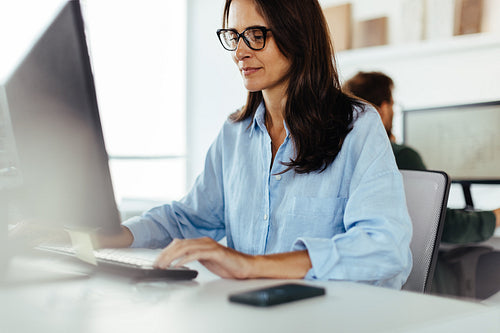 Female software developer working on a computer in an office