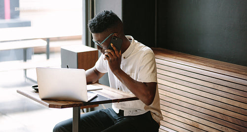 Freelancer working on laptop sitting at a coffee shop
