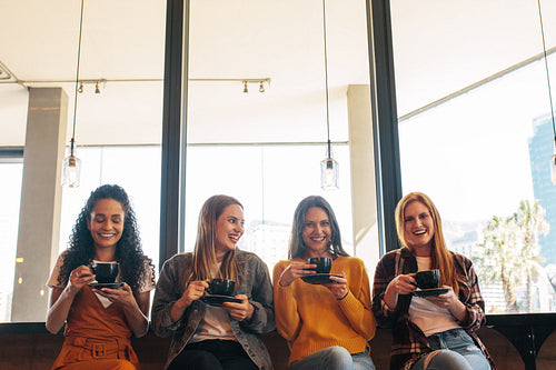 Cheerful women sitting at a cafe drinking coffee