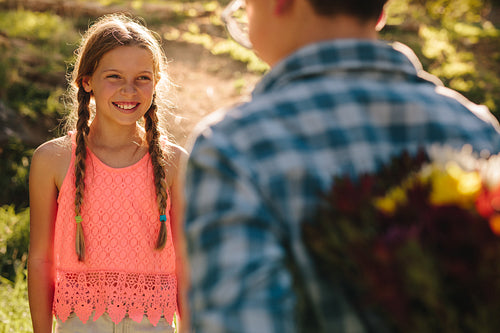 Boy expressing his love to a girl with a bouquet of flowers