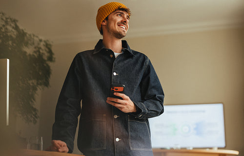 Man checks a smartphone at work in a creative office portrait