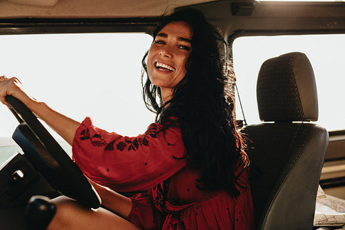 Woman enjoying driving a car on road trip