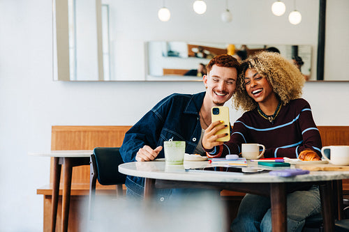 Friends taking a selfie in a cozy cafe
