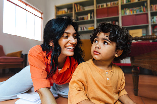 Latina woman and young boy bonding together in a cozy library setting