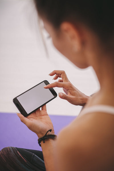 Woman using mobile phone at fitness studio