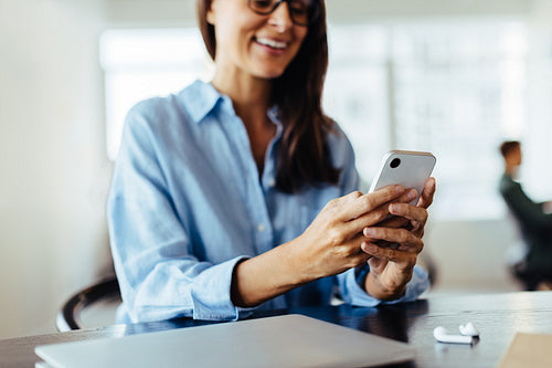 Professional woman using a cell phone in an office