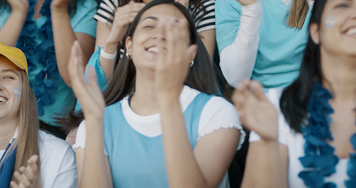 Fans at live game clapping and cheering for their team