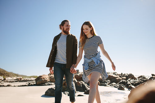 Beautiful couple strolling along a rocky beach