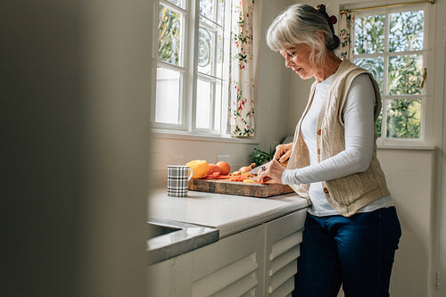 Senior woman working in kitchen at home