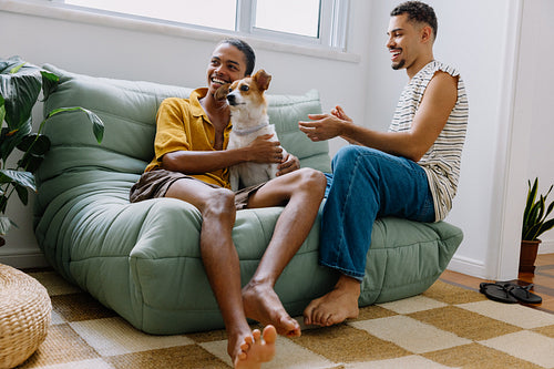 Couple bonding at home with their dog on a cozy sofa