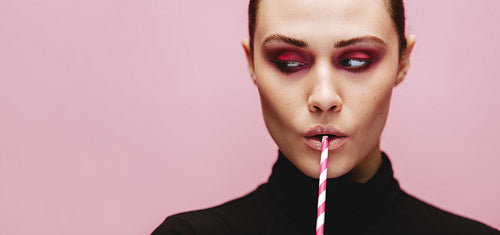 Beautiful female with a straw looking away