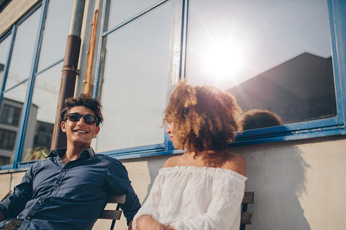 Young couple sitting outdoors and talking