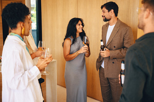 Friends enjoying wine and conversation at an elegant home during evening hours