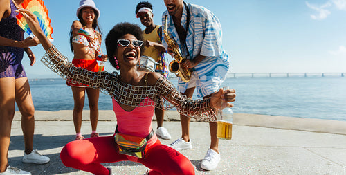 Happy group of friends dancing at a beach party