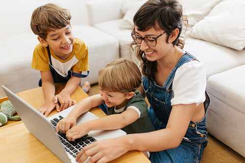 Children enjoying learning laptop with mom at home