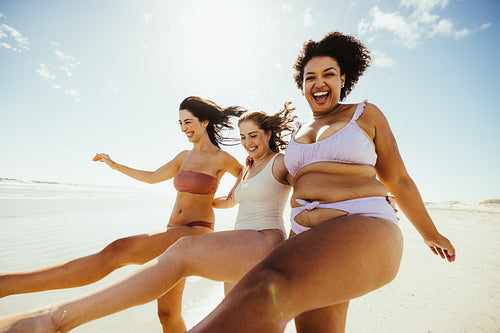 Three happy girlfriends having a good time at the beach