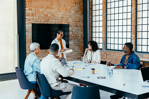 Business team having a productive meeting in a contemporary workspace with brick walls and large windows