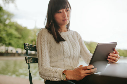 Young woman reading ebook on her digital tablet