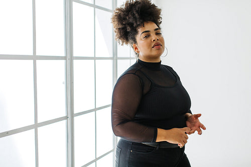 Woman in black casuals standing by window