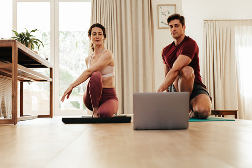 Couple going yoga watching fitness video on laptop
