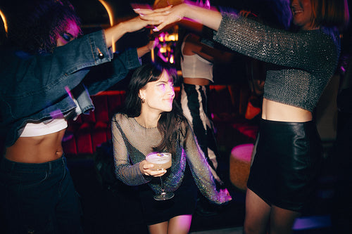 Vibrant night out with friends enjoying drinks and dancing in a lively setting