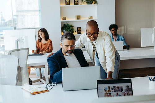 Happy colleagues collaborating on a project in a modern office