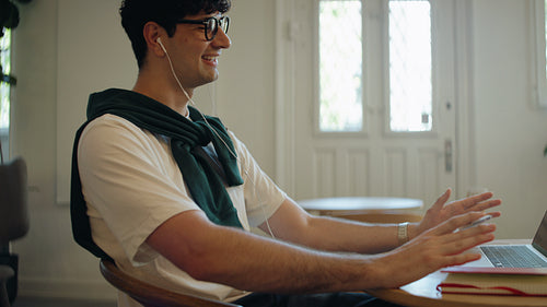 Man laughing on on video call in an indoor workspace