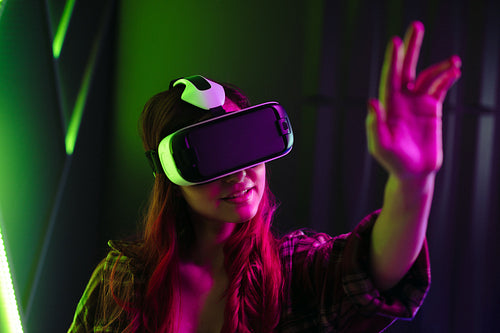 Female gamer exploring a digital world using a VR headset