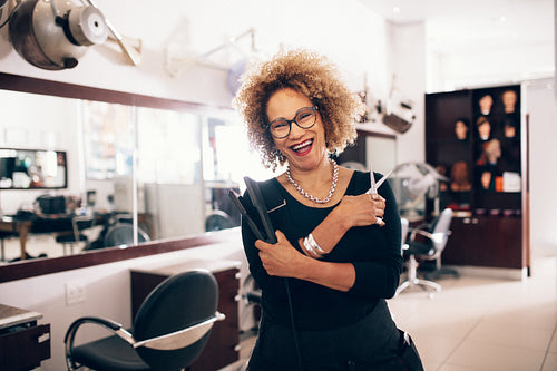 Female hairdresser at the salon holding hairdressing tools