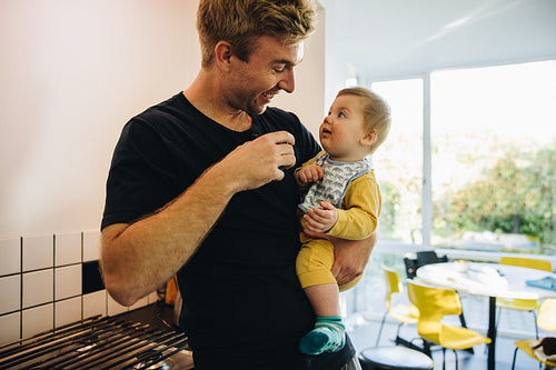 Father drinking coffee holding his baby