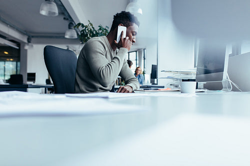 African man talking on mobile phone in office