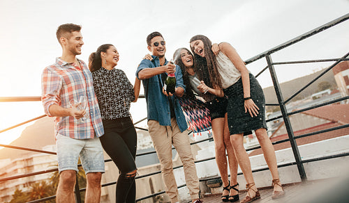 Man opening a bottle of champagne with friends