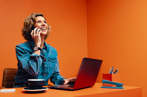Smiling businesswoman in conceptual orange workspace