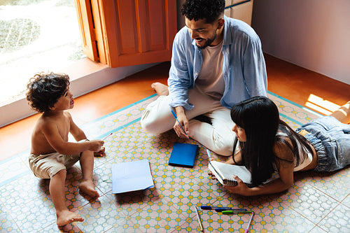 Latino family bonding with creative activities on a sunny day indoors