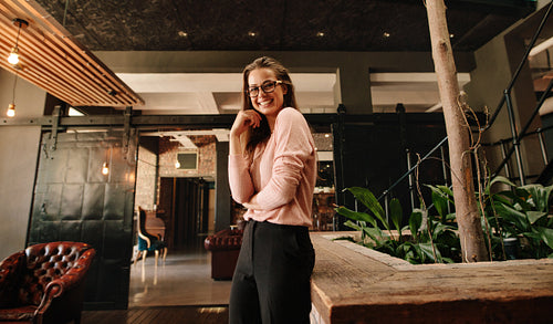 Business woman in office lobby looking happy